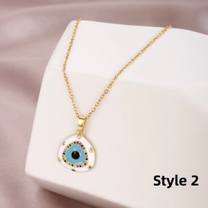 Close-up of golden triangle evil eye pendant with micro-inlaid zircon on white pedestal