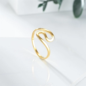 Close-up of polished gold wavy S-curve ring showing smooth fluid lines and reflective metal