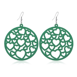 Close-up of green hollow heart wooden earrings with round geometric design on white background