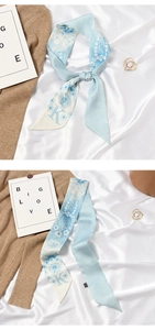 Detail view of floral print skinny scarf with letter K on elegant silk background