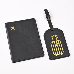 Close-up of black PU leather passport cover and luggage tag with gold foil travel patterns