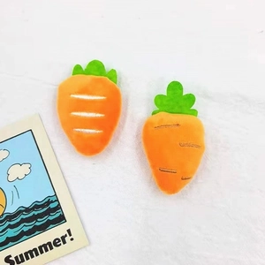 Cute plush carrot brooch accessory for backpack and hat decoration on white fabric