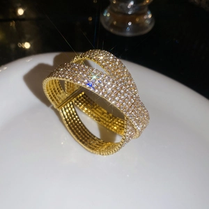 Détail macro d'un bracelet doré luxueux à double couche avec des cristaux de zircon brillants