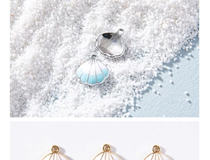 Detailed view of ocean-themed enamel shell charms on sand background for DIY jewelry crafts