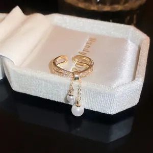 Adjustable gold ring with double rows of pavé diamonds and dangling white pearls