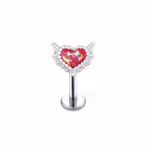 Close-up of heart-shaped labret stud with red opal stone and silver winged details