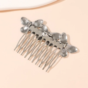 Close-up of vintage silver butterfly hair comb with detailed alloy texture and teeth