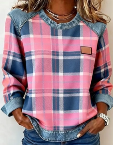 Detail of blue and pink plaid denim patchwork sweatshirt with leather logo patch