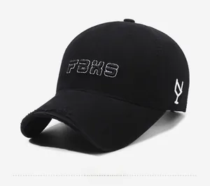 Detail of distressed brim and white FBKS embroidery on a black cotton baseball cap