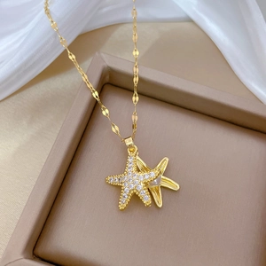Macro detail of gold starfish pendant with white pearls and sparkling zircons