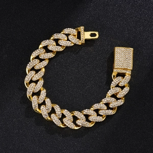 Detailed view of hip hop gold Cuban chain link bracelet with sparkling rhinestones on black