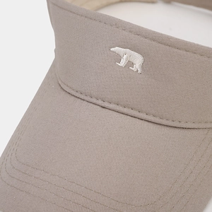 Close-up of white polar bear embroidery on breathable beige cotton sun visor hat