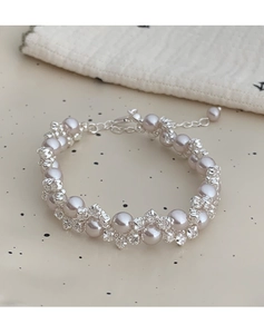 Detailed close-up of a pearl and rhinestone beaded necklace with adjustable lobster clasp