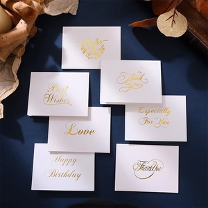 Close-up of elegant gold foil stamped greeting cards with various festive patterns