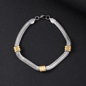 Detail of silver snake chain bracelet with gold accent rings on black leather background