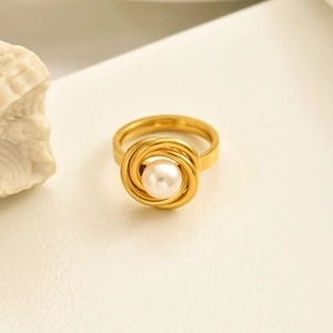 Macro shot of French rose pearl ring with gold spiral setting on a vintage stone background