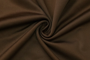Dettaglio del tessuto in maglia marrone caffè con trama a spirale e drappeggio