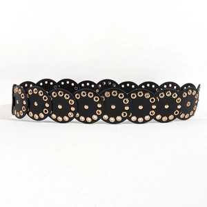 Detail of black wide belt with gold eyelets and punk style scalloped edges on white background