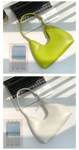 Chic green and beige PU leather shoulder bags displayed on desk with artistic lighting