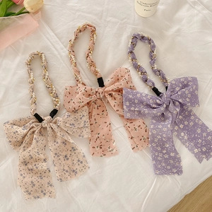 Detailed view of floral chiffon headbands with pearls and decorative bows in three colors