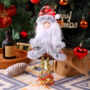 Close-up of Santa Claus ornament with red plaid hat and bells on a Christmas tree