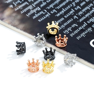 Close-up of crown-shaped zircon beads in gold, silver, rose gold, and black finishes