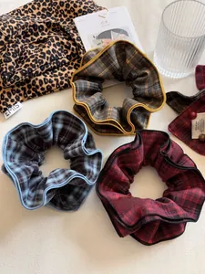 Detailed close-up of retro plaid fabric scrunchies in blue, red and brown tones
