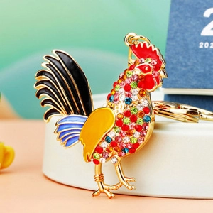 Detailed macro view of gold rooster keychain with colorful rhinestones and enamel finish