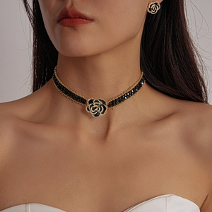 Close-up of a gothic black rose flower choker necklace and matching stud earrings