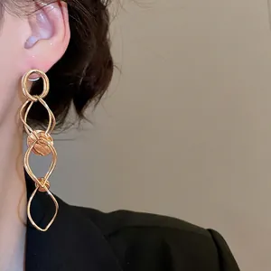 Elegant gold layered circular drop earrings with tassel design worn by a model