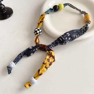 Detail of floral fabric heart pendant with ethnic wood beads and patterned spacers