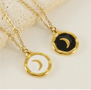 Macro shot of gold celestial coin pendants with black and white enamel crescent moons