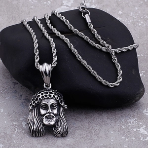 Detailed macro shot of vintage silver Jesus head pendant on a twisted chain
