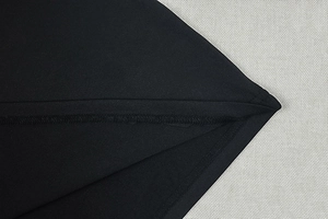 Detail of the black fabric stitching and high-quality texture on a fitted maxi dress