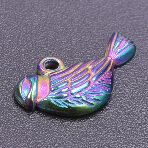 Macro view of fish-shaped metal pendant with iridescent rainbow finish and relief texture
