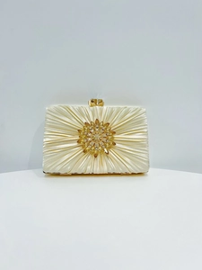 Detail einer champagnerfarbenen Abendtasche aus Seide mit Strassblume und goldenem Rahmen