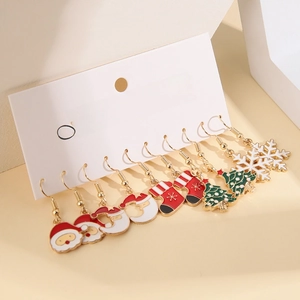 Close-up of 5 pairs of Christmas earrings featuring Santa, snowflakes, and festive trees