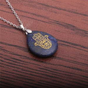 Detailed top view of a Hamsa Hand pendant necklace with lapis lazuli on wood