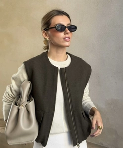 Close-up of deep brown zip-up vest featuring large pockets and high-quality texture