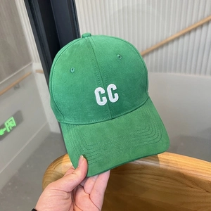 Detailed view of the grass green baseball cap with white CC embroidery and cotton texture