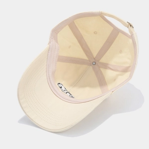 Detail of off-white baseball cap showing inner cotton structure and metal buckle