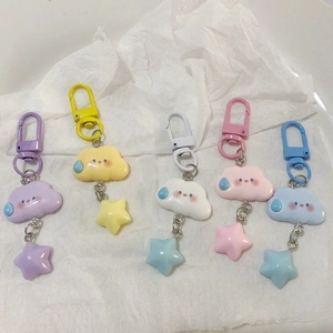 Detail of colorful cloud and star keychains in pastel purple, yellow, white, and pink