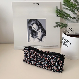 Floral corduroy pouch with zipper and Merci Paris label on a stylish desk setting