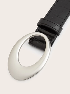 Close-up of matte silver oval buckle and crocodile pattern texture on the leather belt