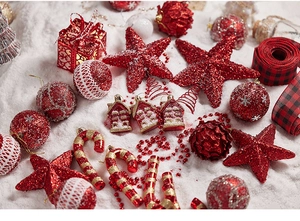 Flat lay of red and gold Christmas star, baubles, and festive ornaments on white fur