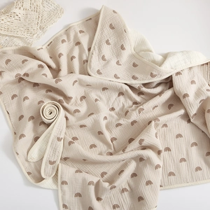 Soft beige muslin cotton baby swaddle blanket with brown rainbow prints on white background