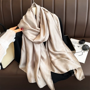 Champagne satin silk scarf draped elegantly showing smooth glossy texture and soft drape