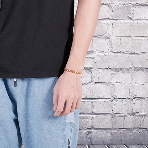 Close-up of 18K gold plated titanium steel flower chain bracelet worn on female wrist