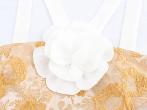 Detail einer großen weißen 3D-Blume und floralem Jacquard auf einem beigen Crop-Top