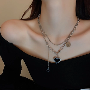 Détail du collier à deux couches en acier avec cœur pixel et pendentif gravé